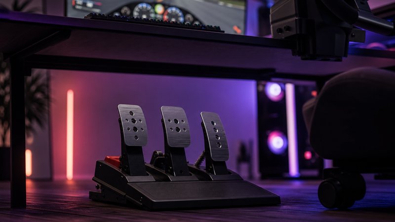 Budget sim racing pedal set under $200 in the foreground of an RGB gaming desk setup